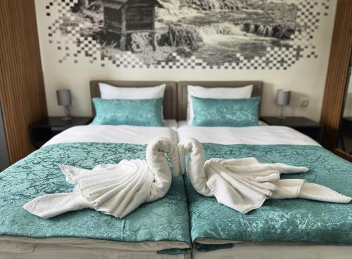 two swans towels are sitting on a bed at Hotel Turist 98 in Jajce