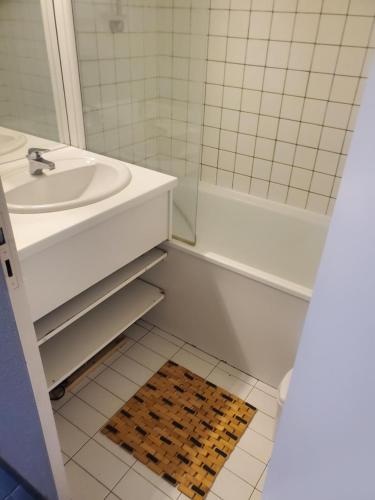 La salle de bains blanche est pourvue d'un lavabo et d'une douche. dans l'établissement Appartement piscine golf, à Saint-Cyprien