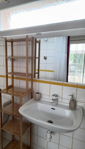 une salle de bain avec un lavabo blanc et un miroir dans l'établissement Gîte 2 pers dans havre de paix cévenol, à Laroque
