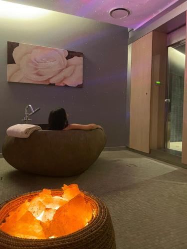 a woman laying in a large tub in a room at Bes Hotel Terme a Palazzago in Palazzago