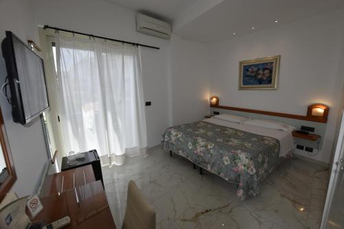 a hotel room with a bed and a television at Hotel Condor in Taormina