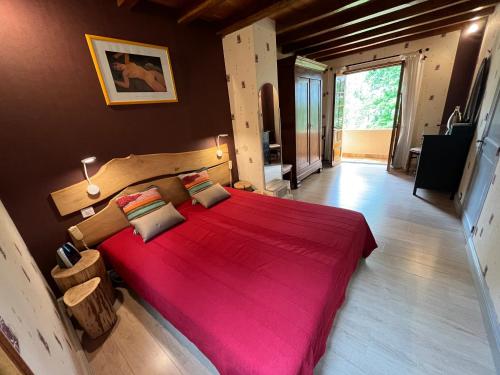 a bedroom with a large bed with a red blanket at Maison de Vacances MACOU 2 in Capdrot