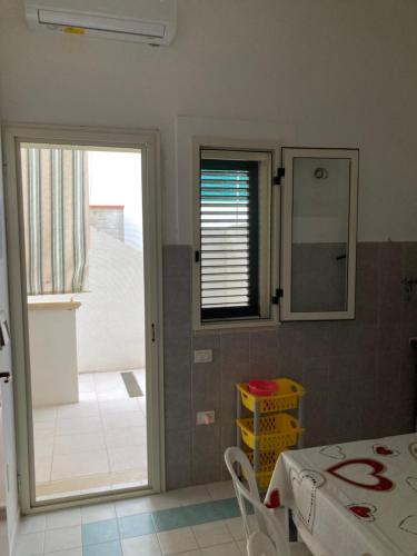 a kitchen with a table and a mirror and a door at Hesperia case vacanze in Vieste