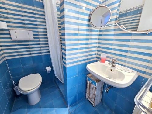 un bagno blu e bianco con un water e un lavandino di Maridea - Biscaglina a Ponza