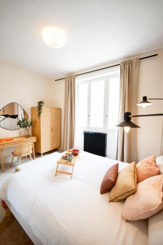 un grand lit blanc dans une chambre avec un bureau dans l'établissement Villa Vichéia - Appartement 14, à Vichy