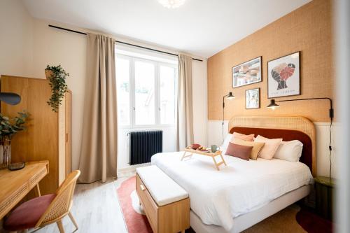um quarto com uma grande cama branca e uma janela em Villa Vichéia - Appartement 14 em Vichy