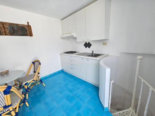 una cucina con pavimento blu e mobili bianchi di Maridea - Biscaglina a Ponza
