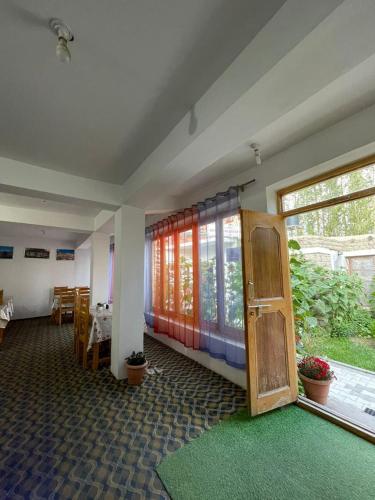 a room with a large window and a green rug at Seven Seas Guest House leh in Leh
