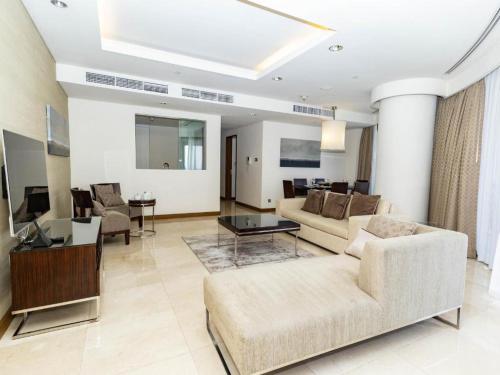 a living room with a couch and a table at Fashion avenue Dubai Mall -The Residence in Dubai