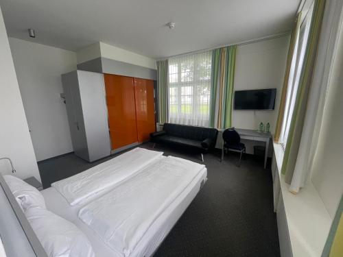 a hotel room with a bed and a desk and a bed at Hotel & Gasthaus Die Perle in Perlen