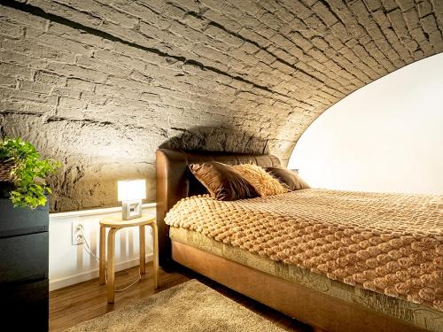 a bedroom with a bed and a brick wall at Laura apartment in Budapest