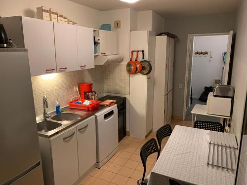 a small kitchen with a sink and a refrigerator at Résidence avec piscine et box, vue sur mer in Sète