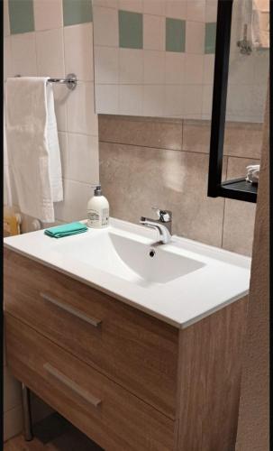 une salle de bain avec un lavabo blanc et un miroir dans l'établissement MyAppart Ivry sur Seine / Bercy, à Ivry-sur-Seine