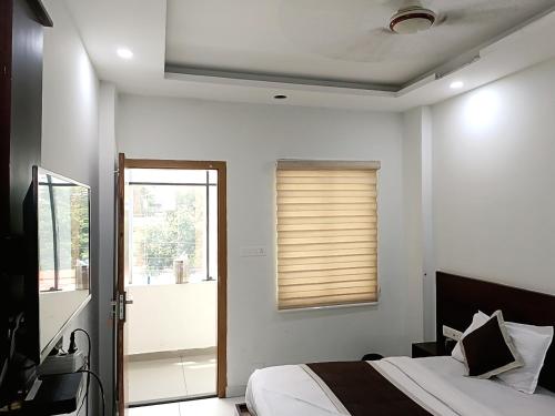 a bedroom with a bed and a window at Grace Tourist Home in Ernakulam