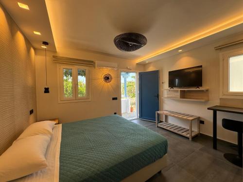 a bedroom with a bed and a flat screen tv at Casa di Angela in Mikonos