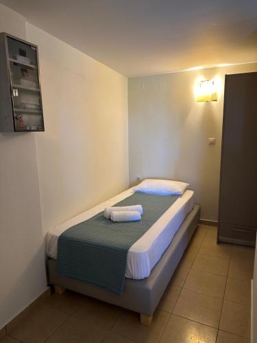 a small bedroom with a bed with towels on it at Balcony Rooms in Elafonisi
