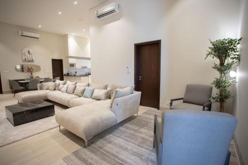 a living room with a couch and a table and chairs at The Hawana Pearl لؤلؤة هوانا in Salalah