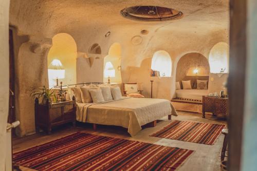 ein großes Schlafzimmer mit einem Bett und einem Sofa in der Unterkunft Kale Konak Cappadocia in Uchisar