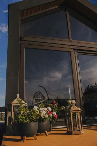 a porch with two potted plants and a window at Chce się być in Ślesin