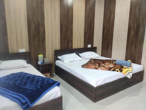 2 camas en una habitación de hotel en Hilans Hotel and Restaurant en Ukhimath