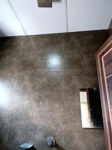 a bathroom with a mirror and a tile floor at Grace Tourist Home in Ernakulam