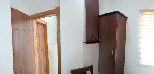a kitchen with a refrigerator and a wooden cabinet at Grace Tourist Home in Ernakulam