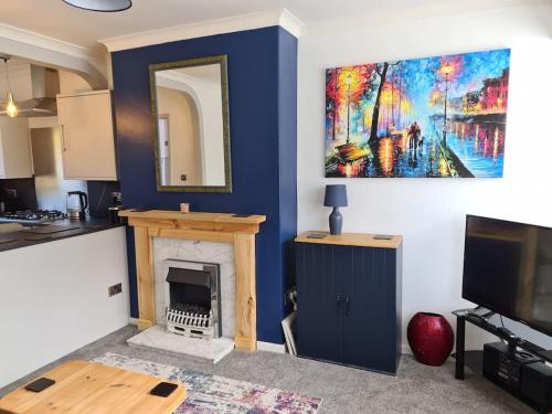 a living room with a fireplace and a painting on the wall at Semi detached quite location in Bridlington