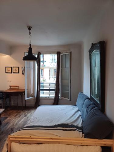 un lit dans une chambre avec une grande fenêtre dans l'établissement Studio in Paris Dupleix, à Paris