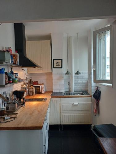 une cuisine avec des armoires blanches et un comptoir en bois dans l'établissement Studio in Paris Dupleix, à Paris