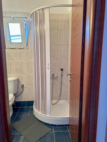 a bathroom with a shower and a toilet at LefCoast AURA Apartments in Paralía Avdhíron