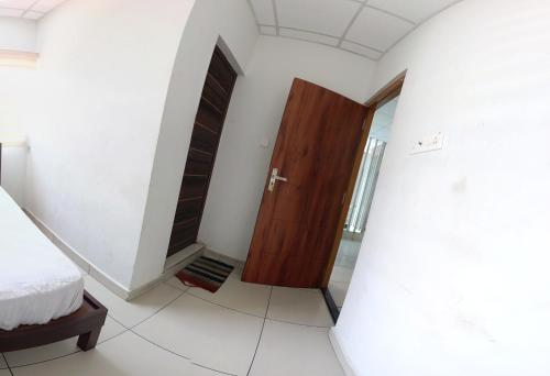 a bedroom with a bed and a wooden door at Grace Tourist Home in Ernakulam