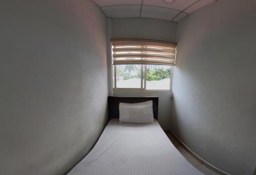 a small bed in a room with a window at Grace Tourist Home in Ernakulam