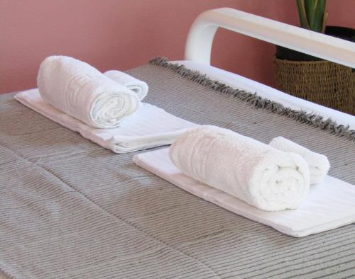 un paio di asciugamani seduti sopra un letto di LefCoast AURA Apartments a Tragasiá