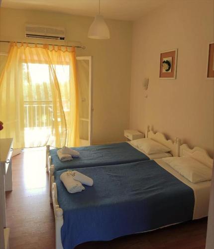 a bedroom with a large bed with towels on it at Firefly Studios Panayiota 15 in Moraitika