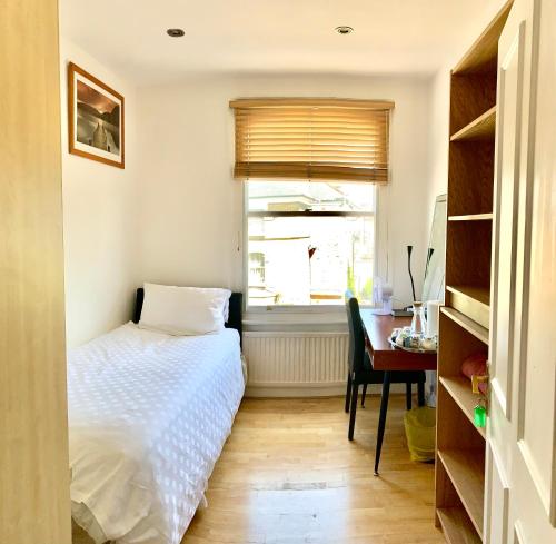 ロンドンにあるベレスフォード ロード ロンドン ルームズのベッドルーム1室(ベッド1台、デスク、窓付)