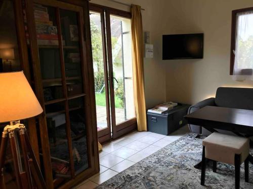 un salon avec un canapé et une table dans l'établissement Maison mer jardin 4 personnes, à Houlgate