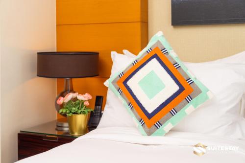 a bed with a pillow on a table with a lamp at Fashion avenue Dubai Mall -The Residence in Dubai