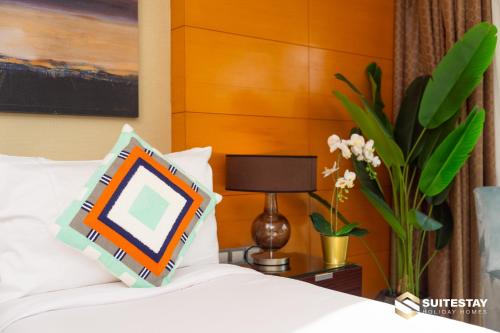 a bedroom with a bed with a vase of flowers at Fashion avenue Dubai Mall -The Residence in Dubai