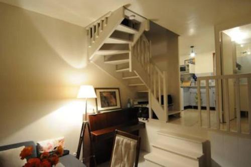 - un salon avec un escalier en colimaçon dans une maison dans l'établissement Maison mer jardin 4 personnes, à Houlgate