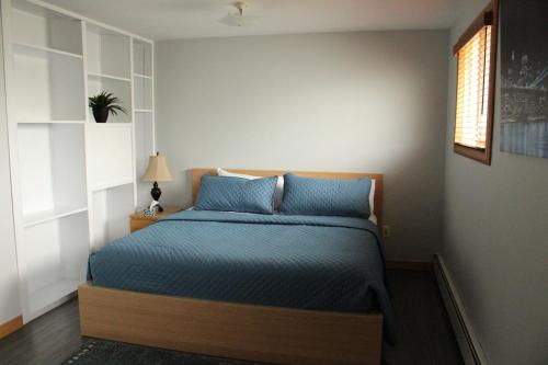 Schlafzimmer mit einem Bett mit blauer Bettwäsche und einem Fenster in der Unterkunft The Regis in Halifax