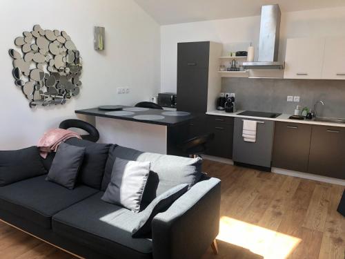 a living room with a couch and a kitchen at la cerisiere in Bessenay