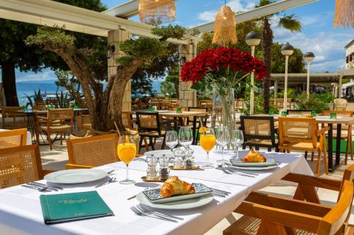 a table with plates of food and glasses of orange juice at Hotel Adria in Malinska