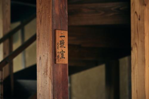 a wooden door with asian writing on it at hotel jin #JIN in Tsushima