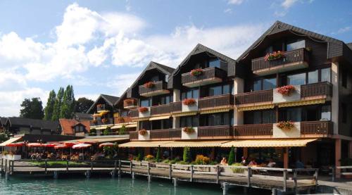 a hotel on the water next to a body of water at Hotel-Restaurant Seegarten-Marina in Spiez