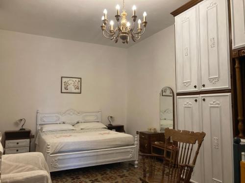 a bedroom with a white bed and a chandelier at La Maison Di Monica in Polignano a Mare