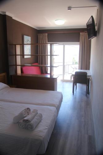 ロザスにあるAparthotel Els Molinsのホテルルーム ベッド2台(タオル付)
