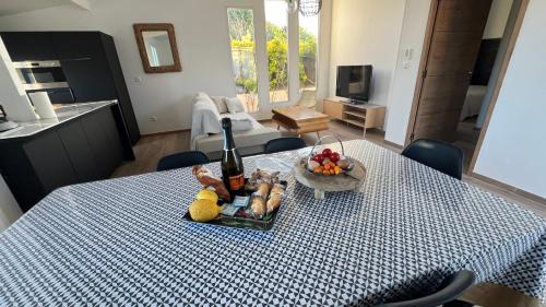 - une table avec une bouteille de vin et un bol de fruits dans l'établissement Villa Altea- Lido Marana - piscine privée exclusive - plage à pied - 3 bedrooms house - private swimming pool - beach access on foot, à Bastia
