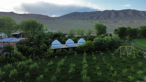 an aerial view of a farm with mountains in the background at Eco Resort Kaiyrma in Bokonbayevo