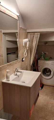 een badkamer met een wastafel en een wasmachine bij Lamarmora 58 in Sassari
