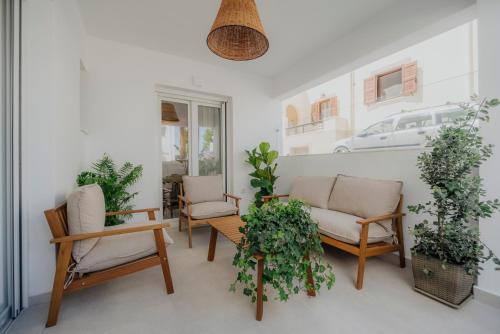a living room with chairs and a couch and plants at Golden Bird's in Naxos Chora